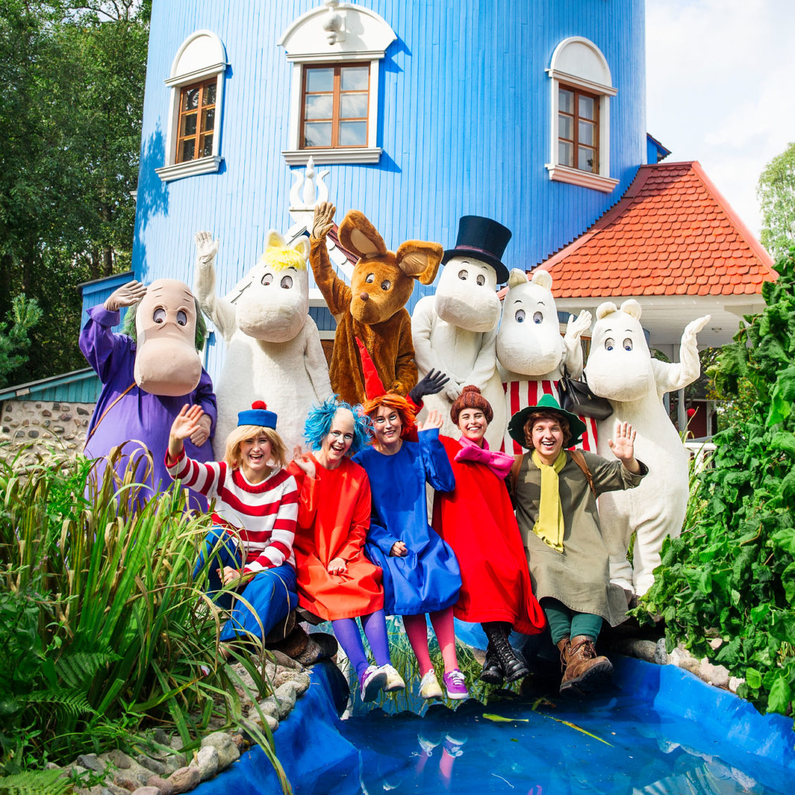 Moomin characters in front of the Moominhouse.
